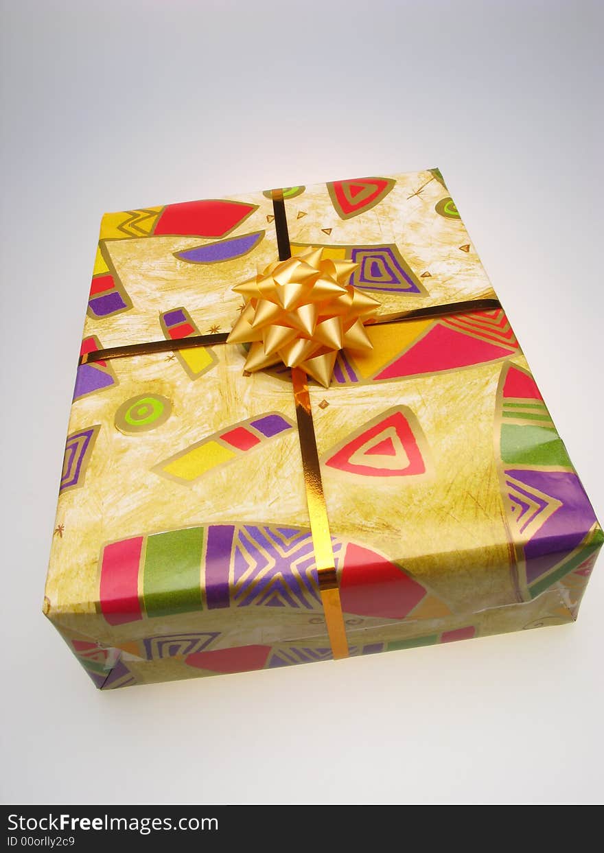 Gift in box packed into bright color paper on white background