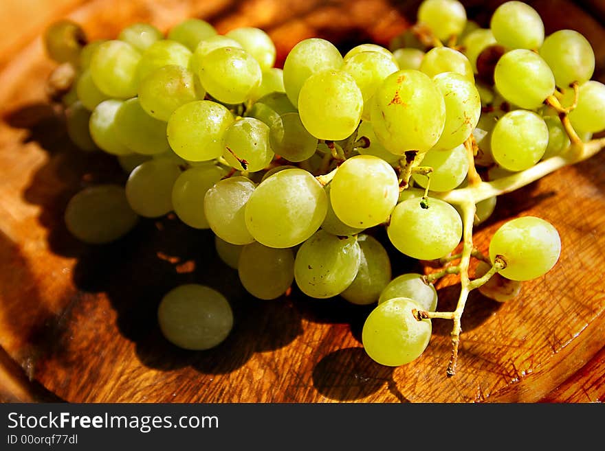 Green grapes on wood under the sun