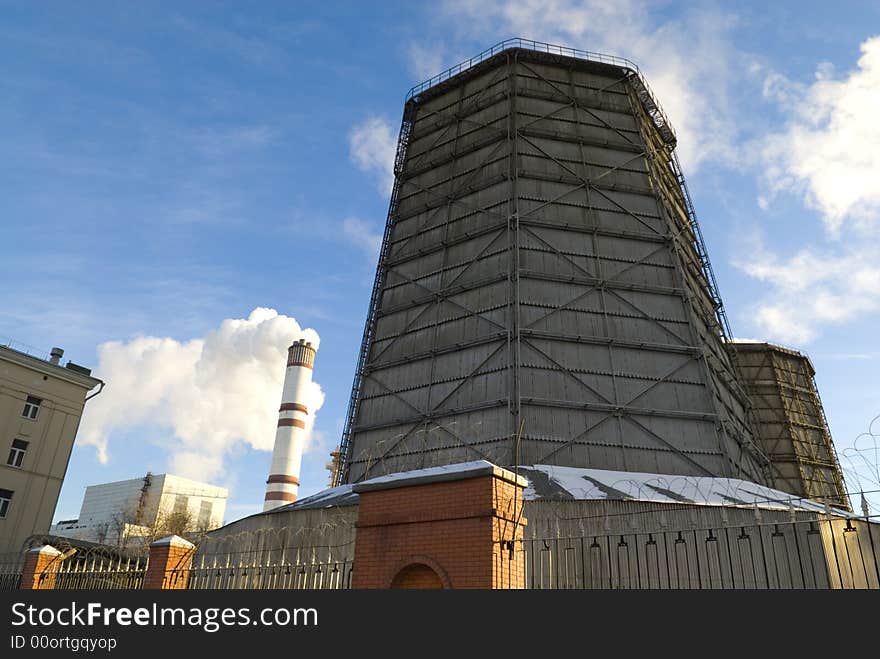 Electric power station chimneys over blue sky