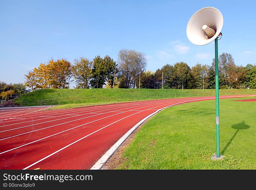 Racetrack for runners and a speaker in the grass. Racetrack for runners and a speaker in the grass