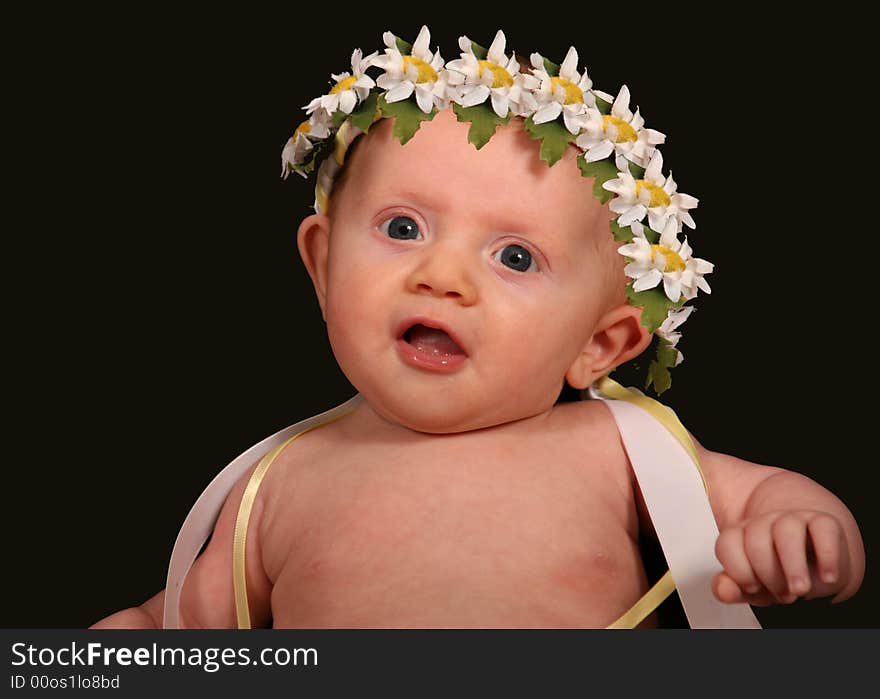 Adorable little baby girl with a crown of daisies on her head. Adorable little baby girl with a crown of daisies on her head