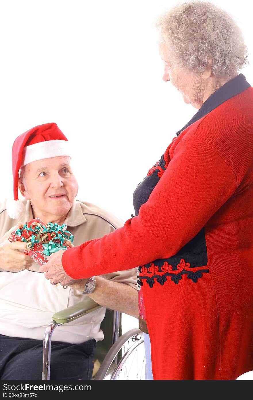 Elderly man in wheelchair giving wife a present isolated on white