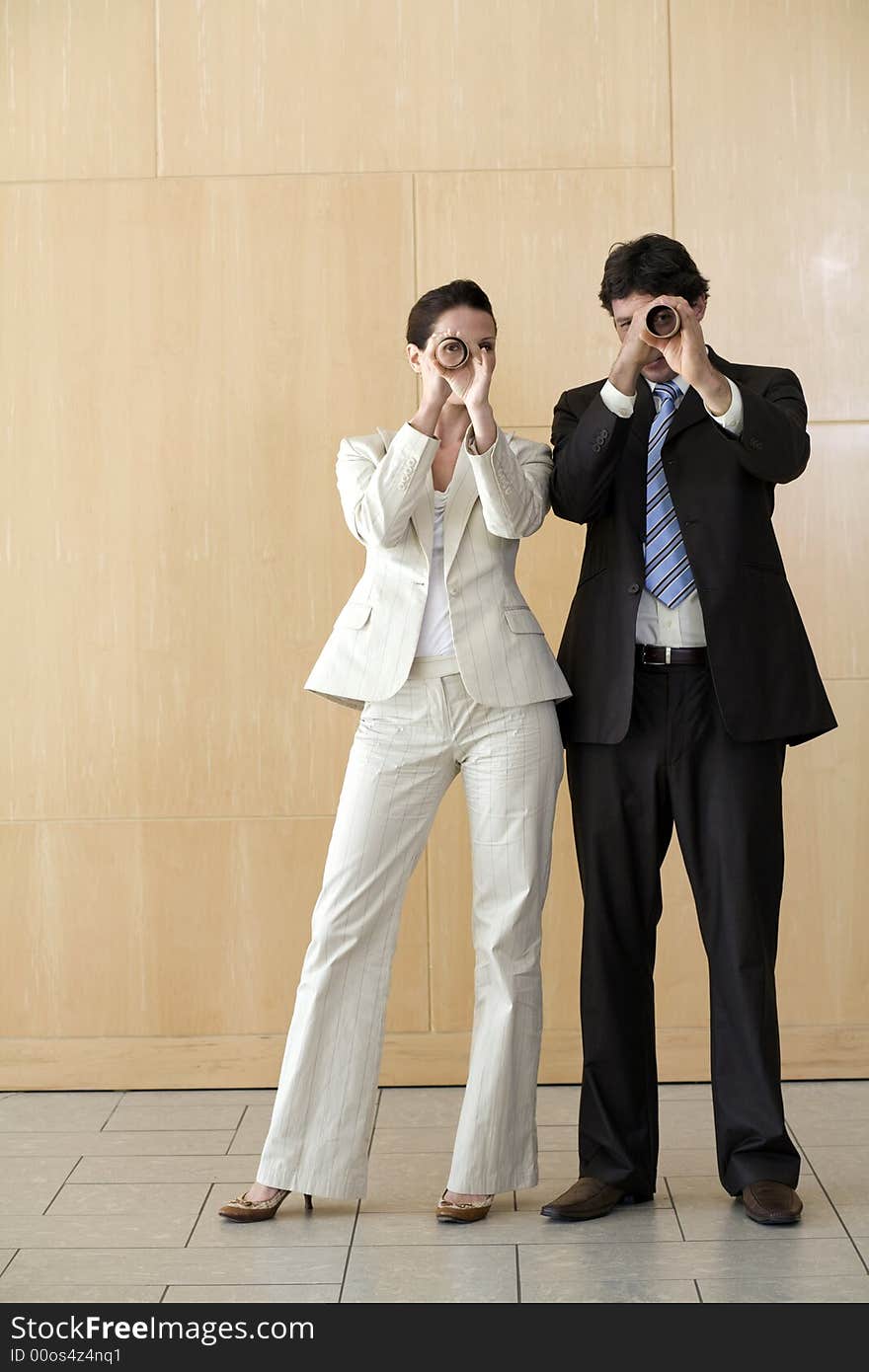 Businesswoman And Man Peering Through Tubes