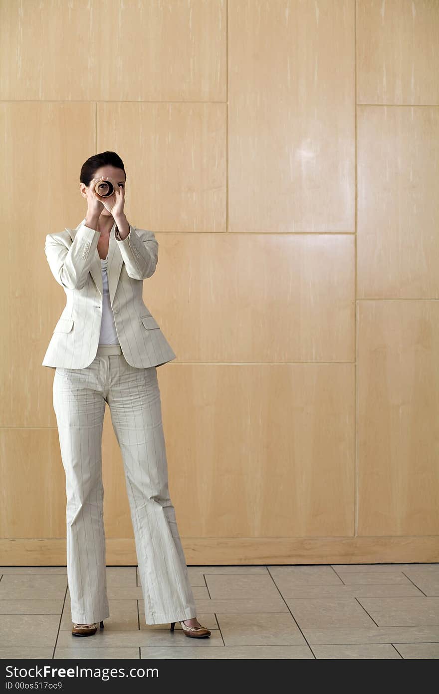 A businesswoman peering through a long tube. A businesswoman peering through a long tube