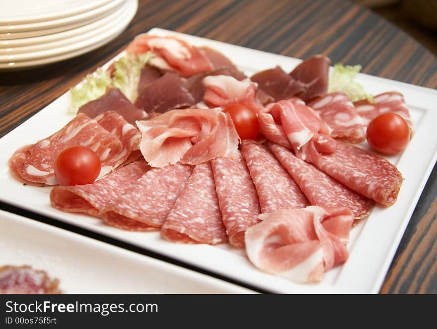 The white square plate with different meat bits. The white square plate with different meat bits