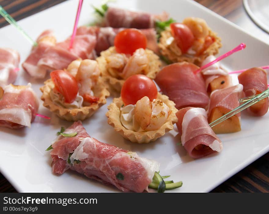 The white plate with different light snacks. The white plate with different light snacks