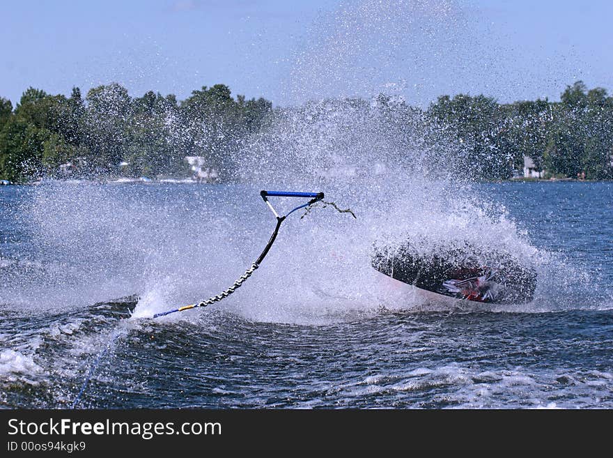 Boy wipes out in the lake trying to do tricks. Boy wipes out in the lake trying to do tricks