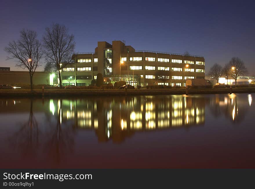 Office building at night, reflecting in water