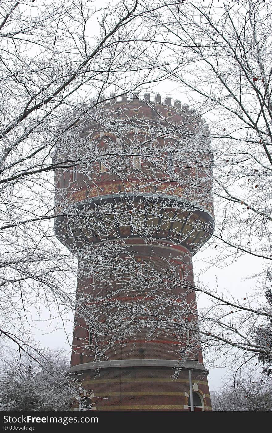 Water pressure tower made of red brick surrounded by winter trees. Water pressure tower made of red brick surrounded by winter trees