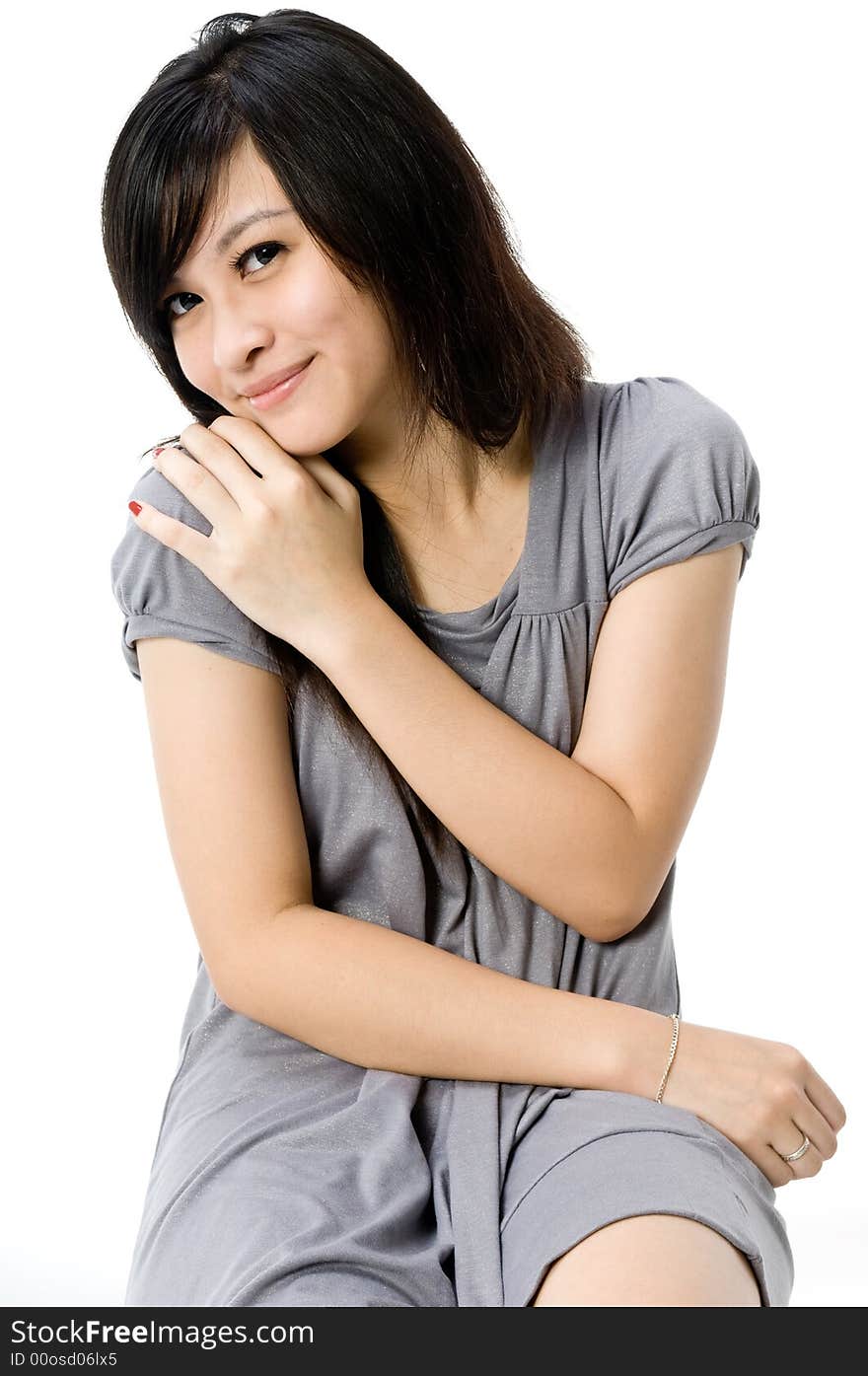 A cute young Asian teenager in grey dress on white background. A cute young Asian teenager in grey dress on white background