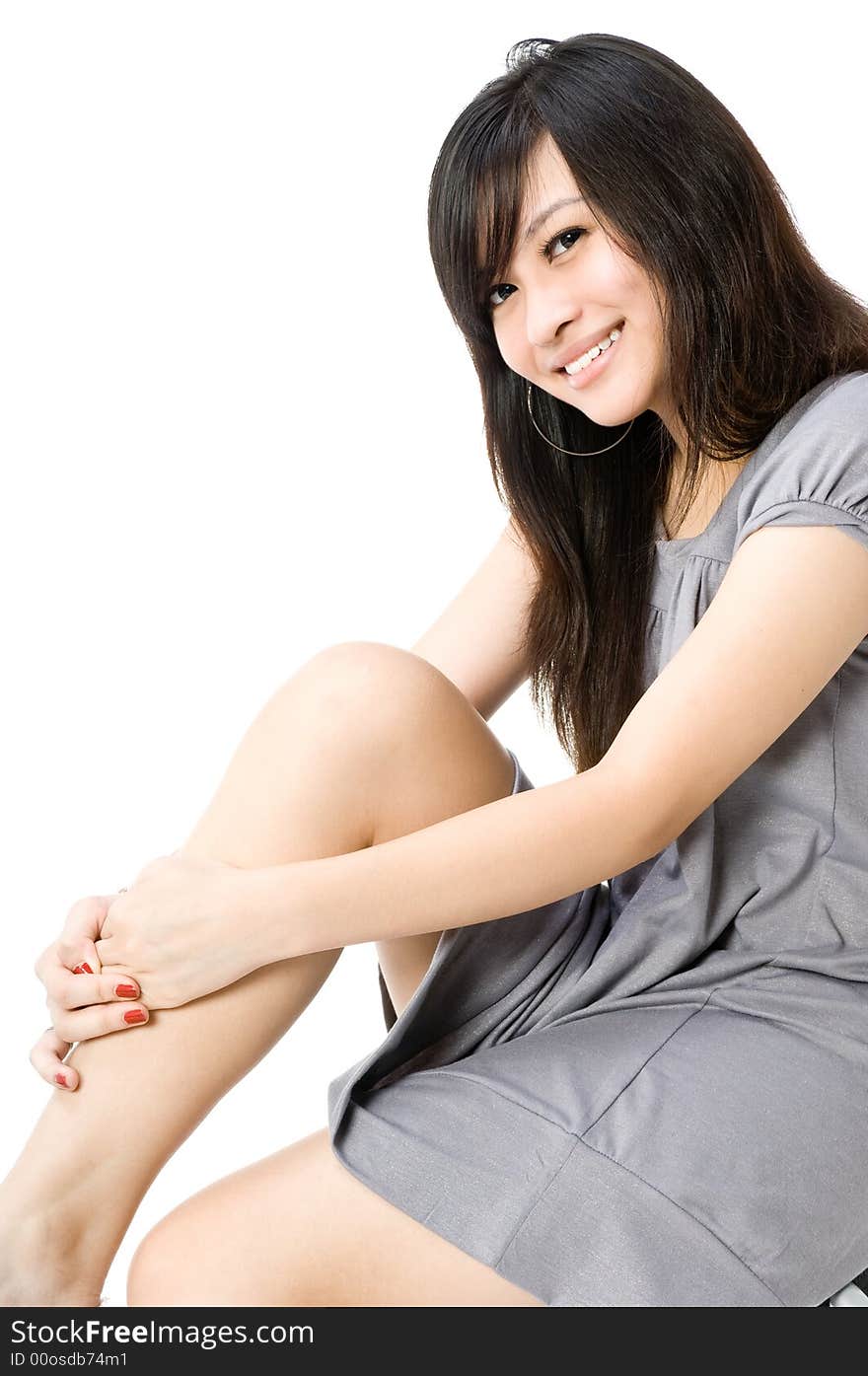 A cute young Asian teenager in grey dress on white background. A cute young Asian teenager in grey dress on white background