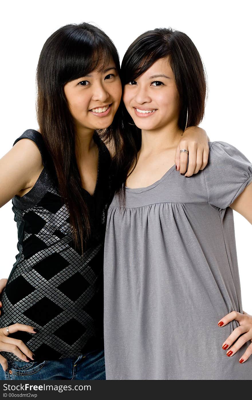 Two young Asian women standing together on white background. Two young Asian women standing together on white background