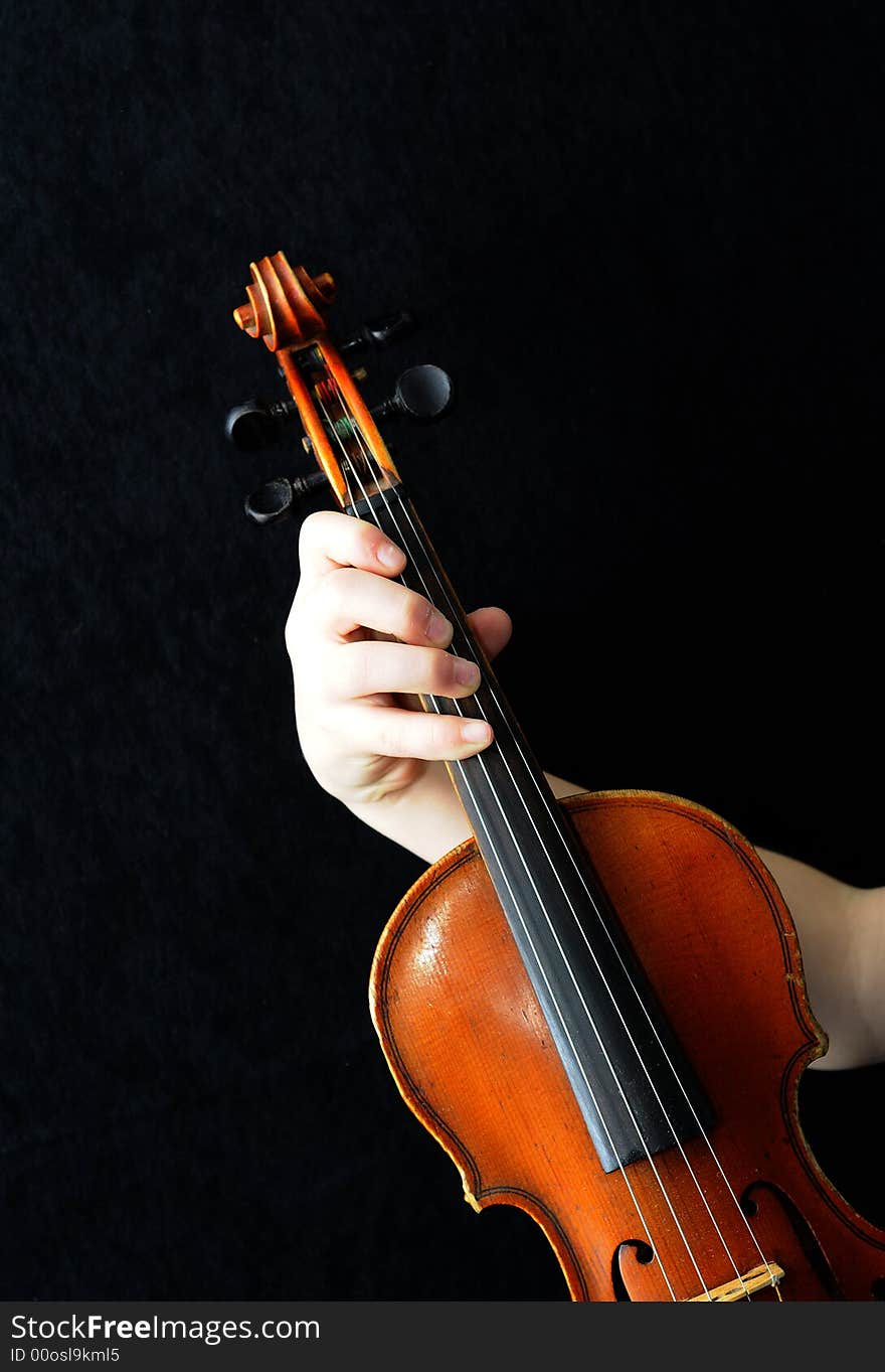 Violinists holding a violin on black