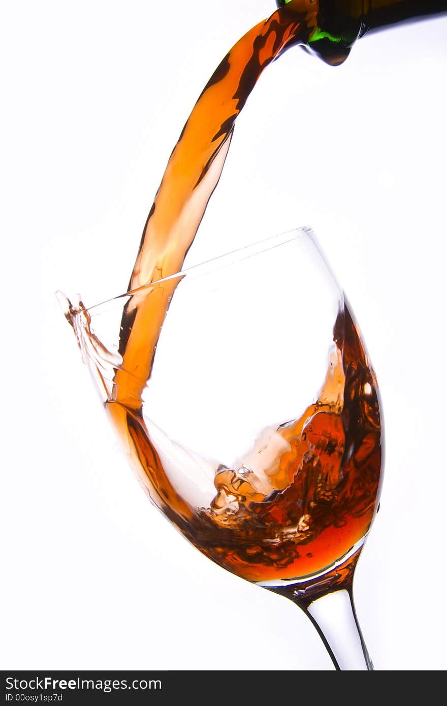 Pouring the red wine into the wineglass in white background. Pouring the red wine into the wineglass in white background.