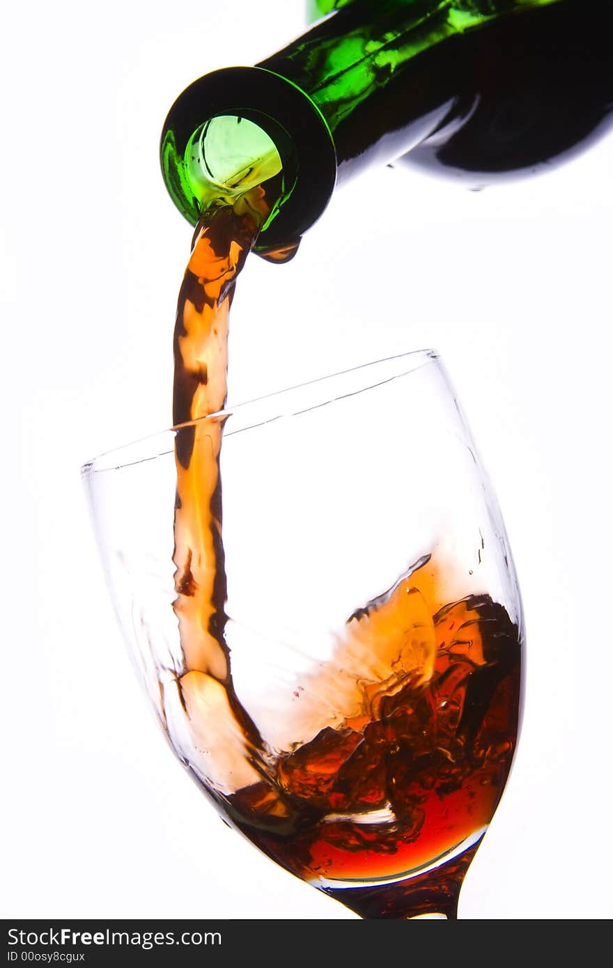 Pouring the red wine into the wineglass in white background. Pouring the red wine into the wineglass in white background.