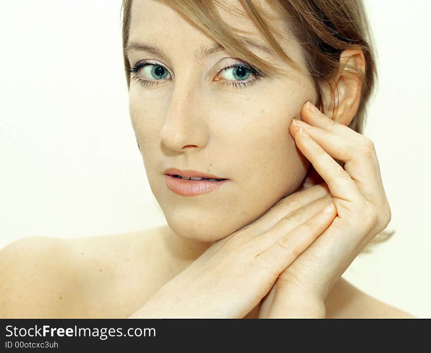 Attractive young woman with hands framing face. White background. Attractive young woman with hands framing face. White background.