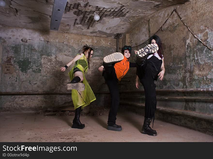 Aggressive girls of goth in a gloomy dirty cellar