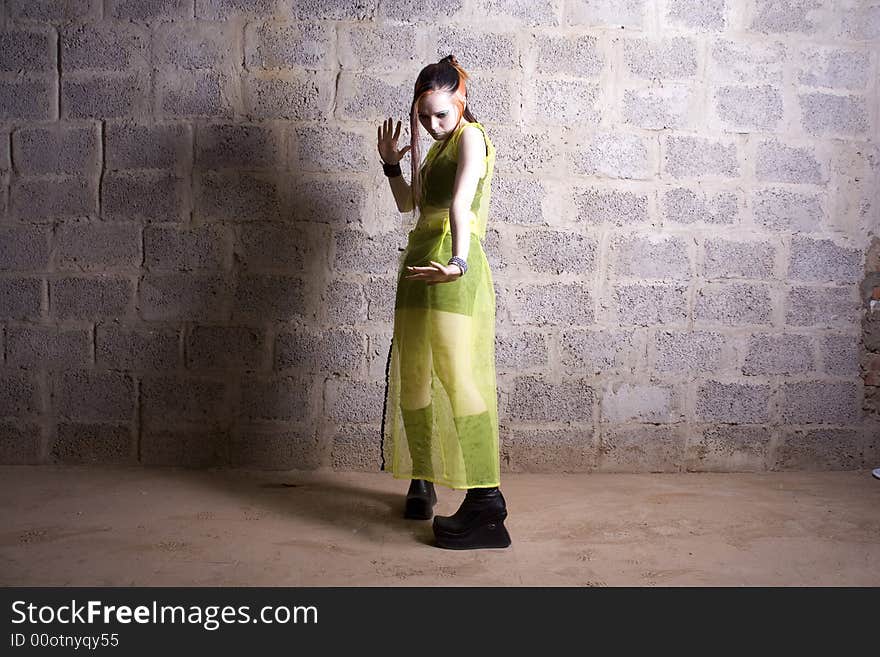 The girl in gothic style make-up on a background of a stone wall