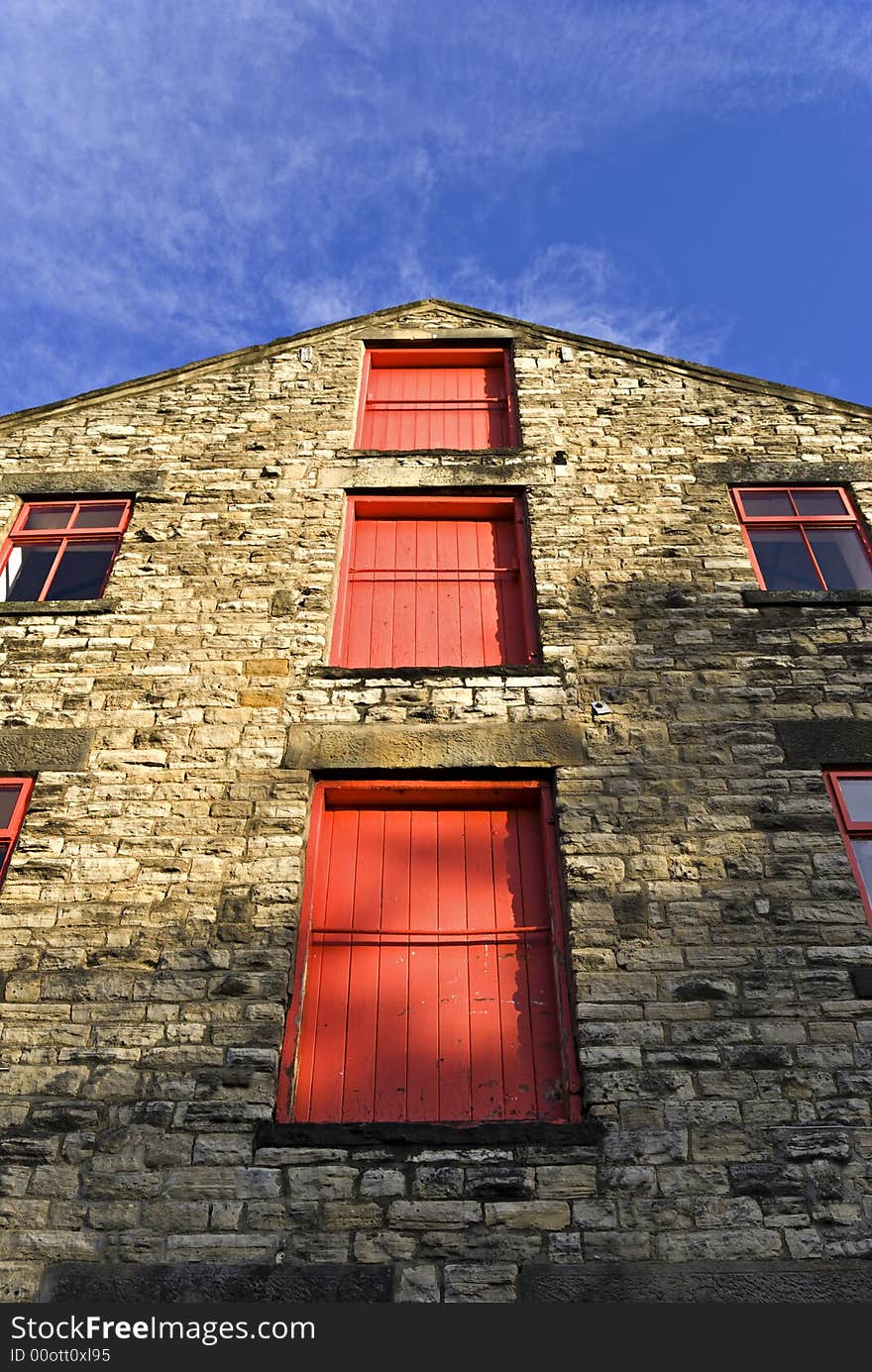 Three red doors on the gable end of a brewery. Three red doors on the gable end of a brewery