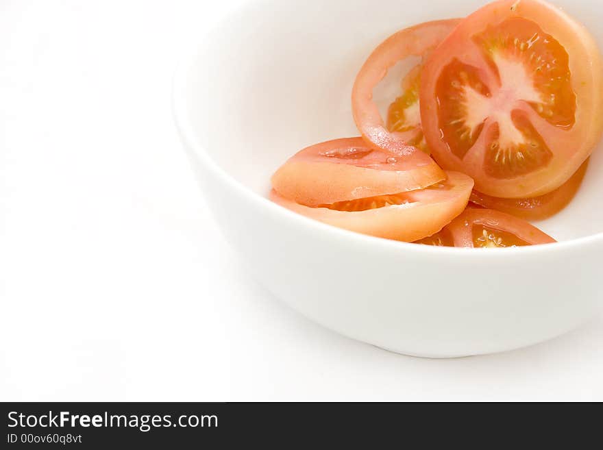 Fresh red tomato in small white ceramic bowl - white background. Fresh red tomato in small white ceramic bowl - white background