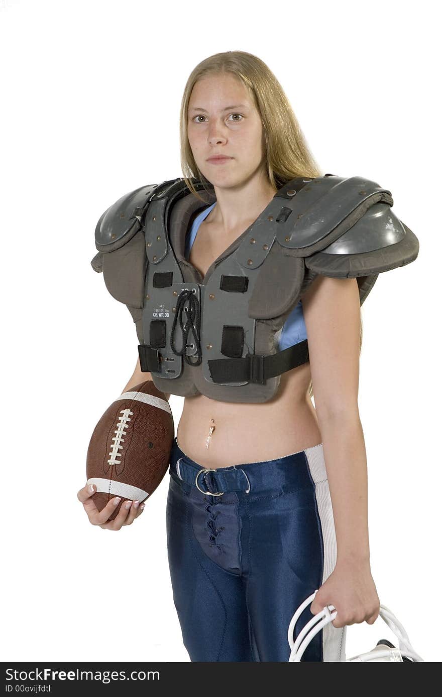 Female football player in shoulder pads holding football. Female football player in shoulder pads holding football.