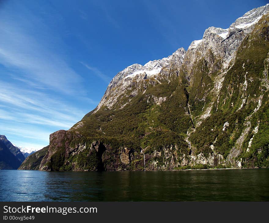 The road to Milford is one of New Zealand’s most scenic drives. The first part is relatively mild farmland, then you’ll ease into beech forest near the entrance to the Fiordland National Park. Look for the Avenue of the Disappearing Mountain and the Mirror Lakes.
Beautiful Milford Sound, described by Rudyard Kipling as the ’eighth wonder of the world’. A cruise on Milford Sound will be an essential component of your time in Fiordland, or you can get up close and personal in a sea kayak. Tall waterfalls, vertical rock faces and seals are some of the things you’ll remember