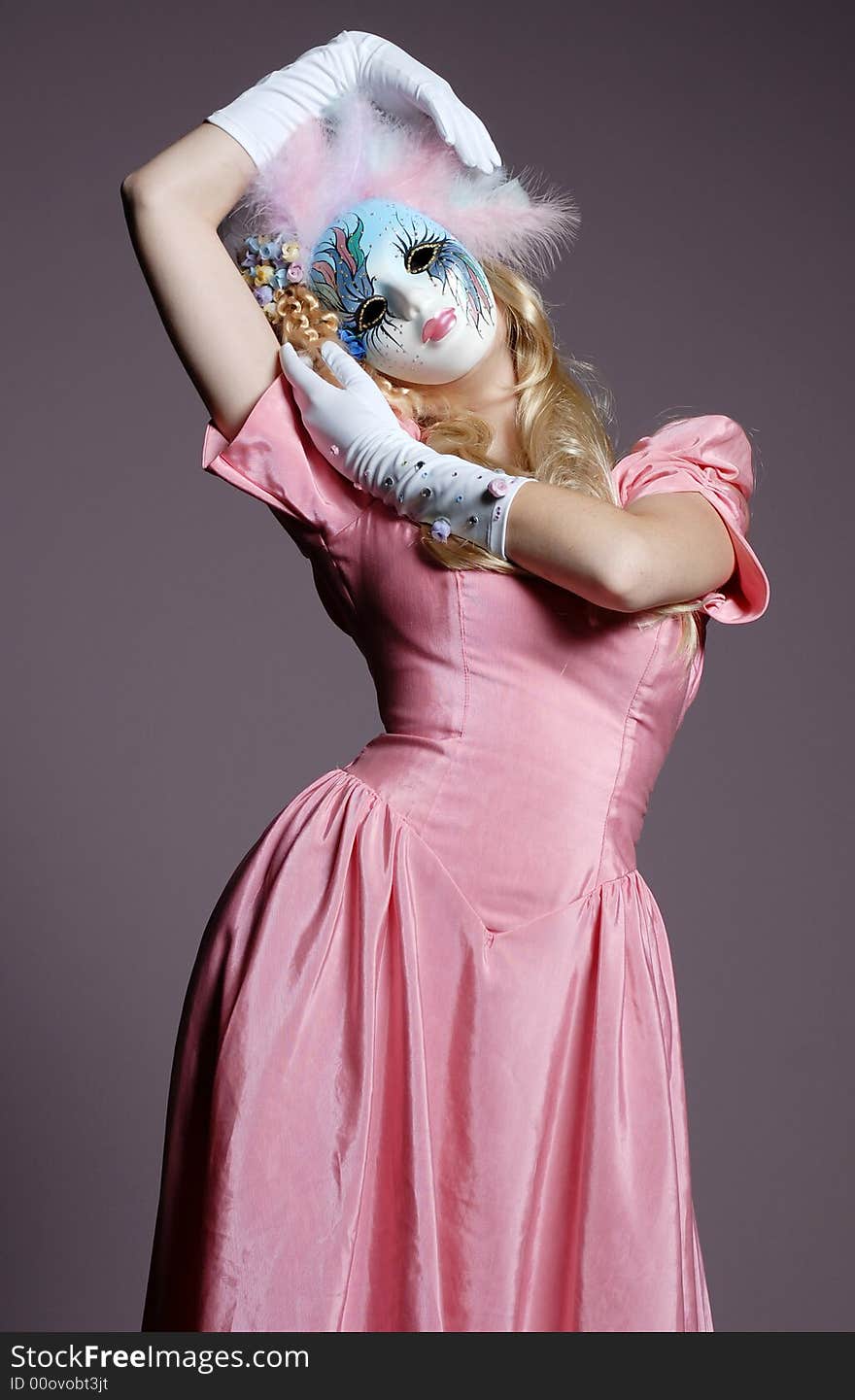 Blonde woman in mask and pink dress. Blonde woman in mask and pink dress