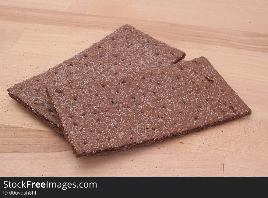 Chocolate Graham Crackers on Wooden Table with Crumbs