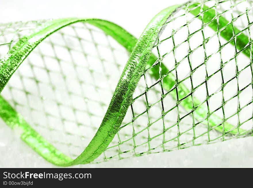 Green Christmas ribbon on snow background