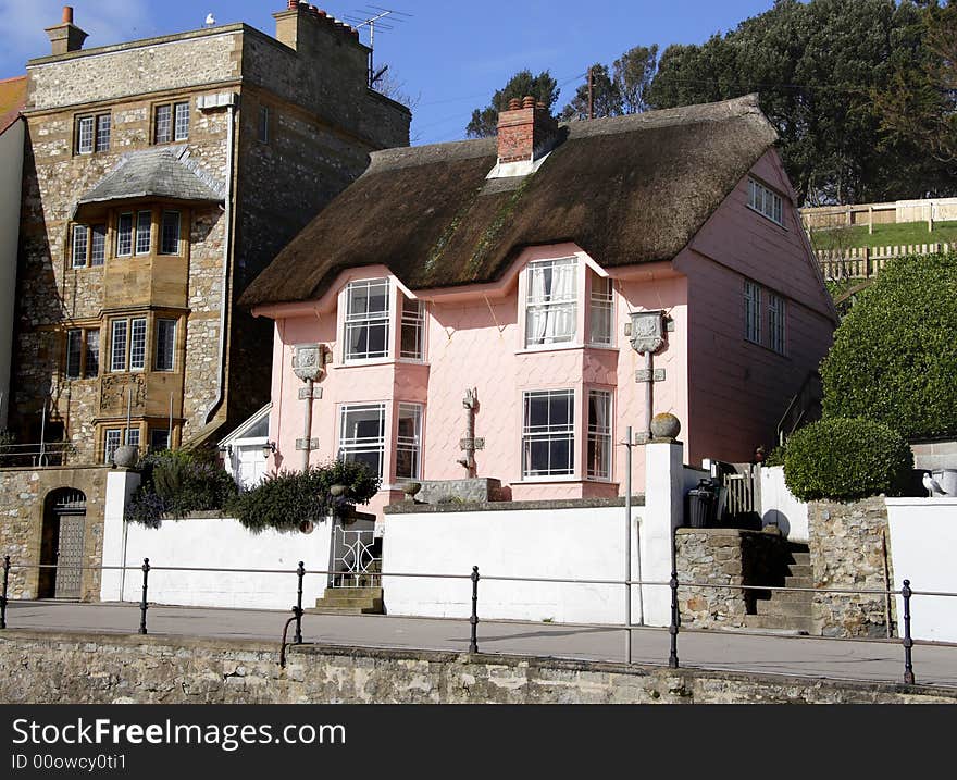 Quaint Thatched Cottage alongside a Seaside Promenade in England. Quaint Thatched Cottage alongside a Seaside Promenade in England.