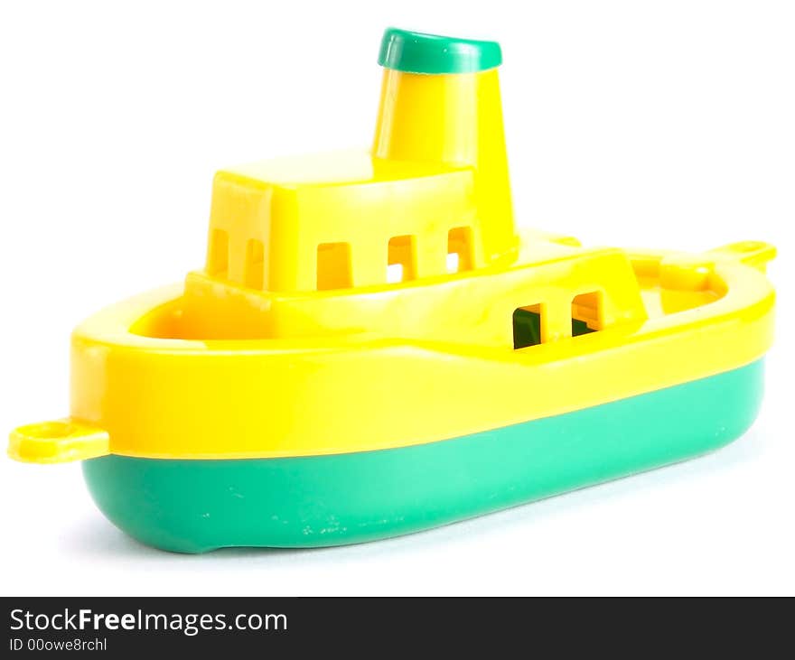 Plastic toy ship. On a white background. Top-yellow. Bottom - 
green.