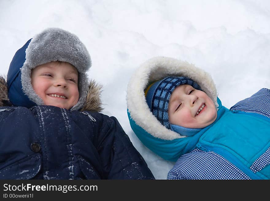 Two cheerful boys lay on a snow. Two cheerful boys lay on a snow