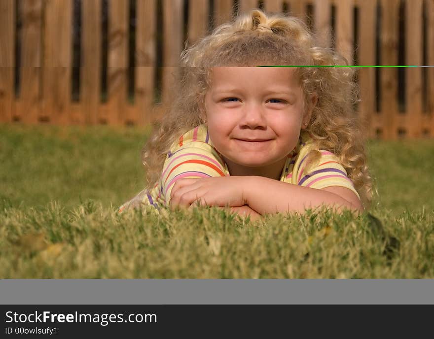 Young girl playing in the grass in the golden light of sunset.  Shallow depth of field.