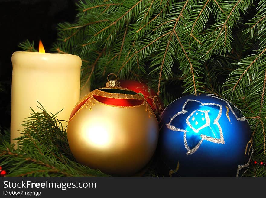 New Year's three spheres and candle on a fur-tree. New Year's three spheres and candle on a fur-tree