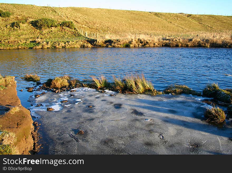 A quiet stretch of river where the water has iced over during the night. A quiet stretch of river where the water has iced over during the night.