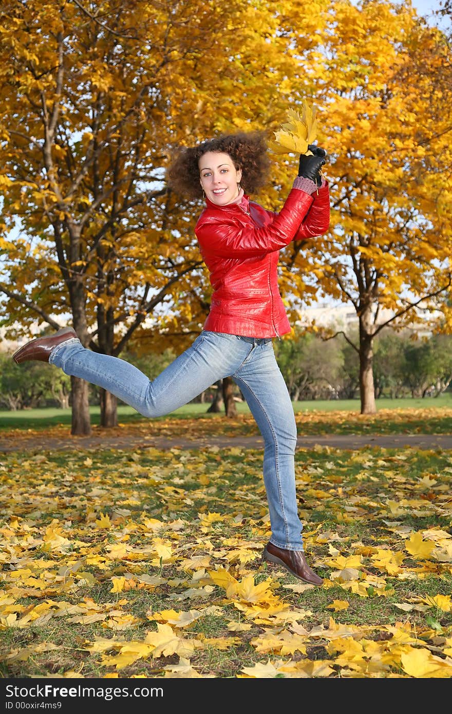 Girl in the red jacket jumps in the park in autumn. Girl in the red jacket jumps in the park in autumn