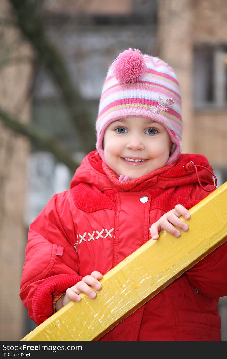 The portrait of girl, who is held for the wooden rails