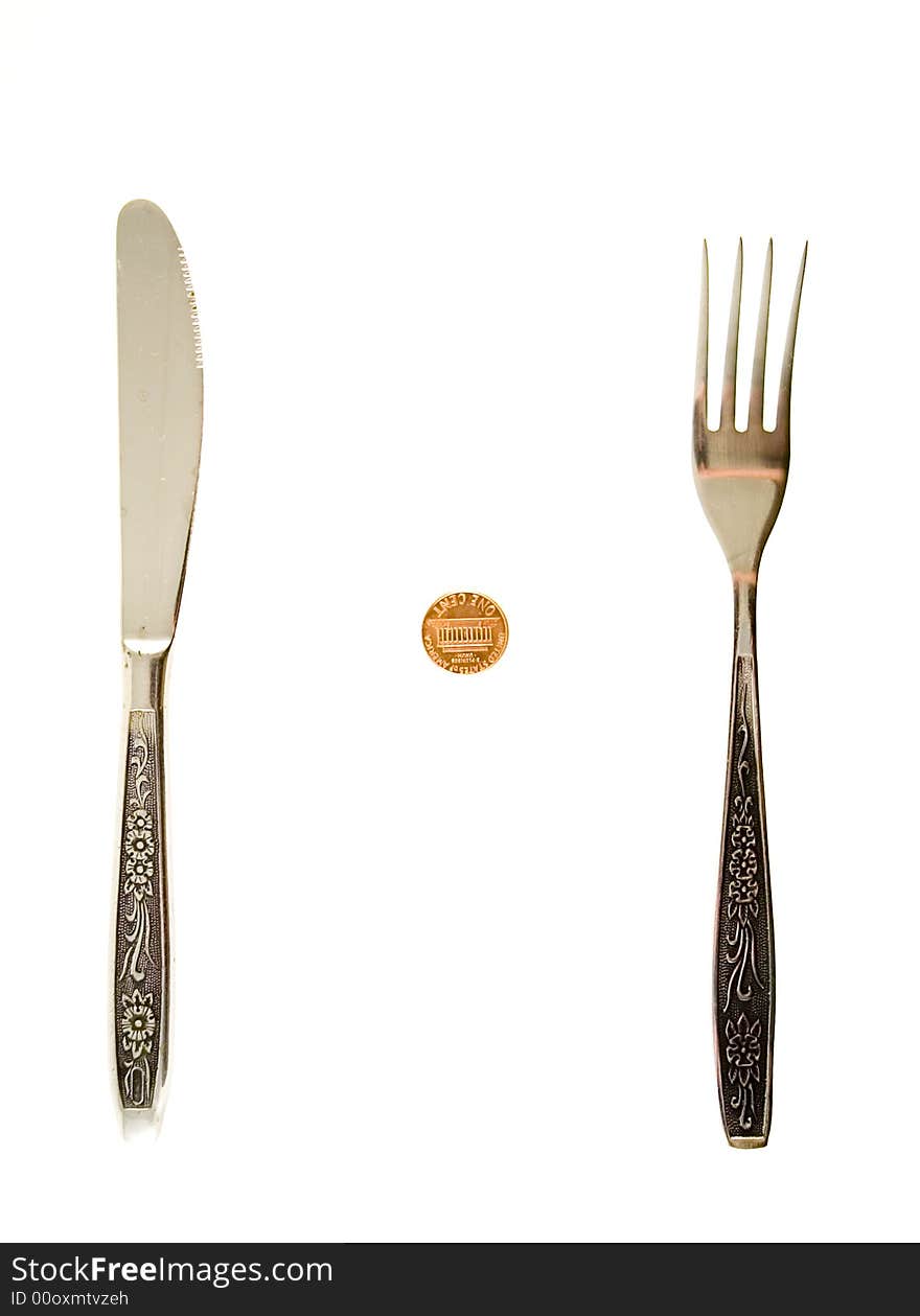 One cent lying between fork and knife. One cent lying between fork and knife