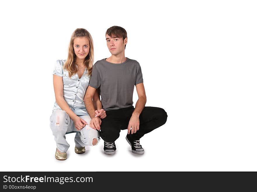 Serious teenager couple sit on white