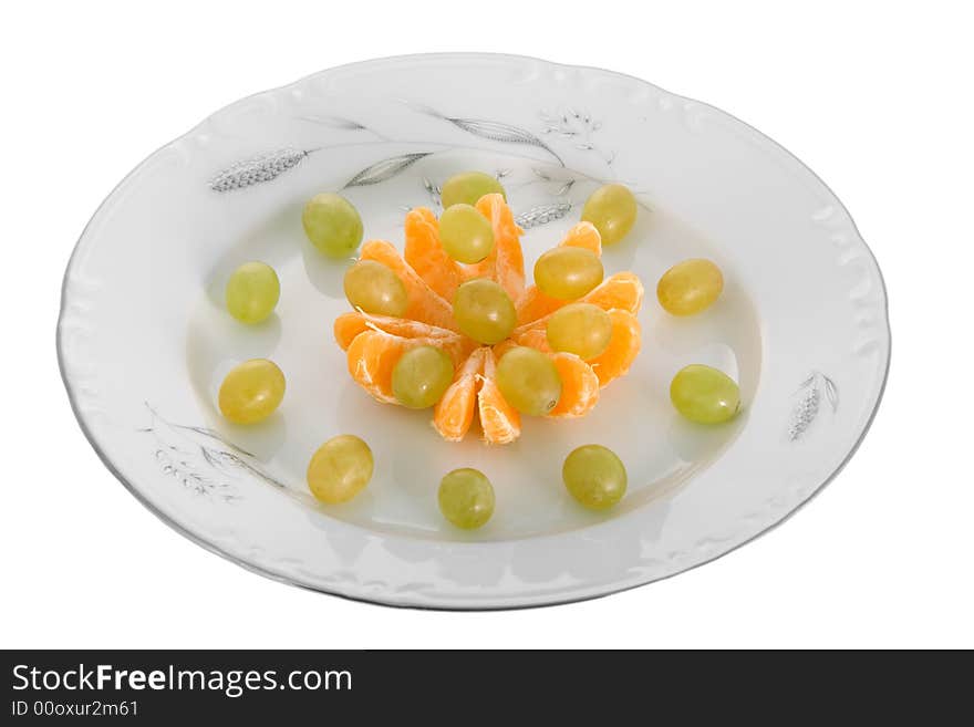 Peeled tangerines and grapes on plate isolated on white