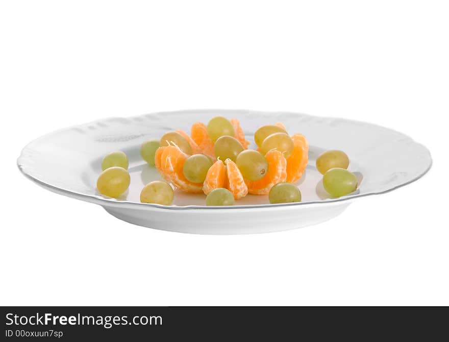 Peeled tangerines and grapes on plate isolated on white