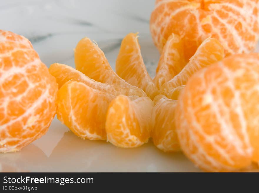 Peeled tangerines on plate isolated on white