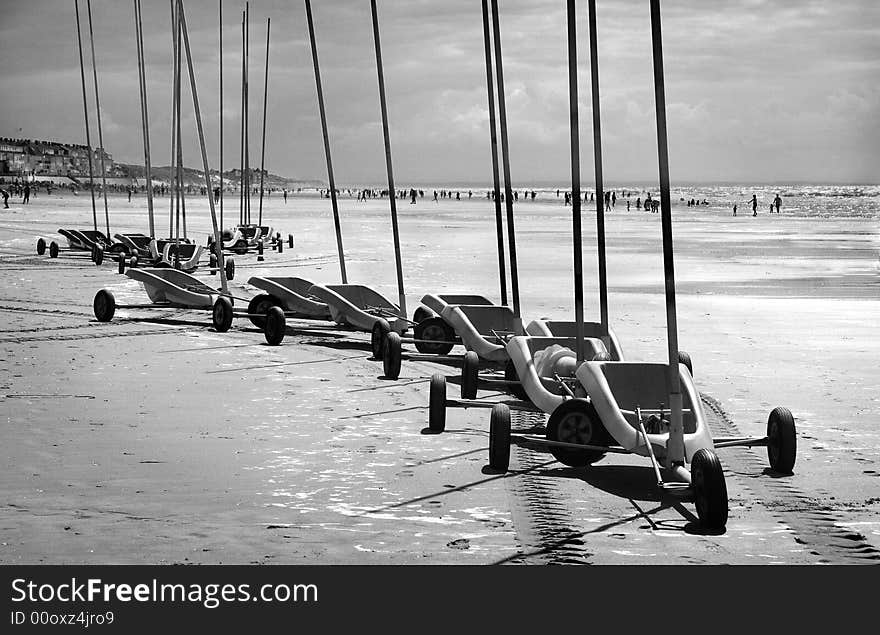 Land sand yachts in a single file on the beach in blach and white