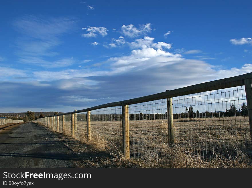 A fence and road in the country. A fence and road in the country