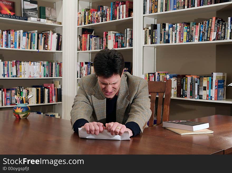 Well-dressed businessman in office setting pushing the metaphorical envelope. Well-dressed businessman in office setting pushing the metaphorical envelope