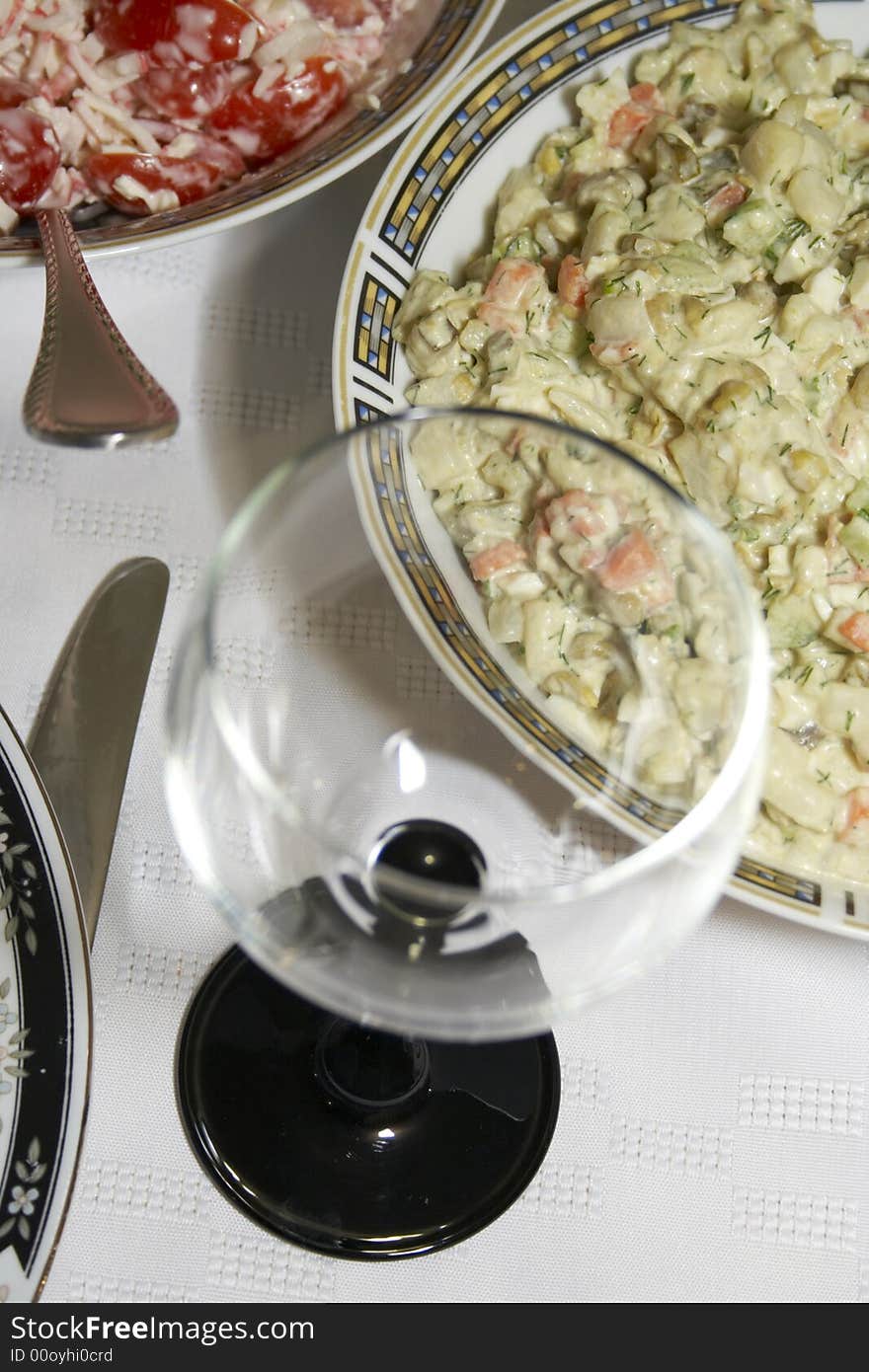 Close-up of served table with salads, plates and glasses. Close-up of served table with salads, plates and glasses