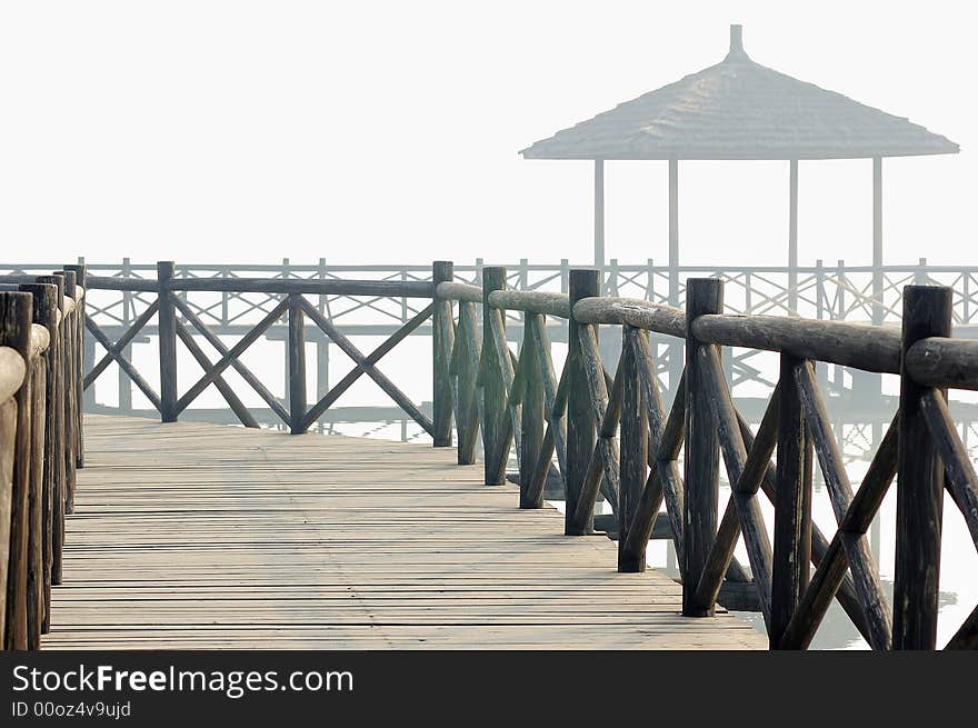 Chinese style pavilion and wooden bridge in fog