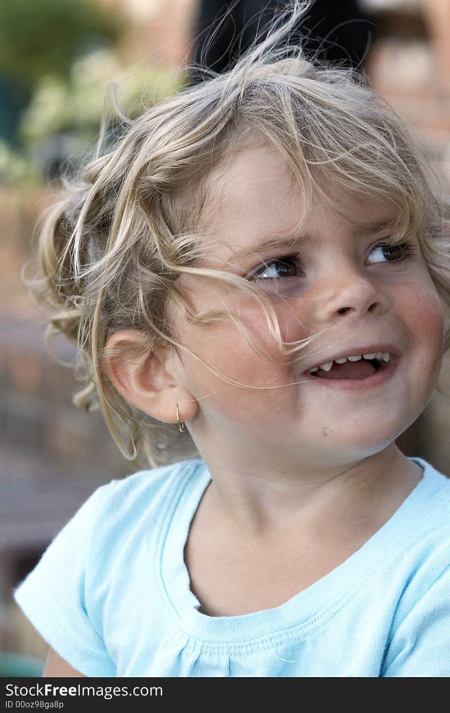 A young girl smiling as her hair is blown by the wind. A young girl smiling as her hair is blown by the wind