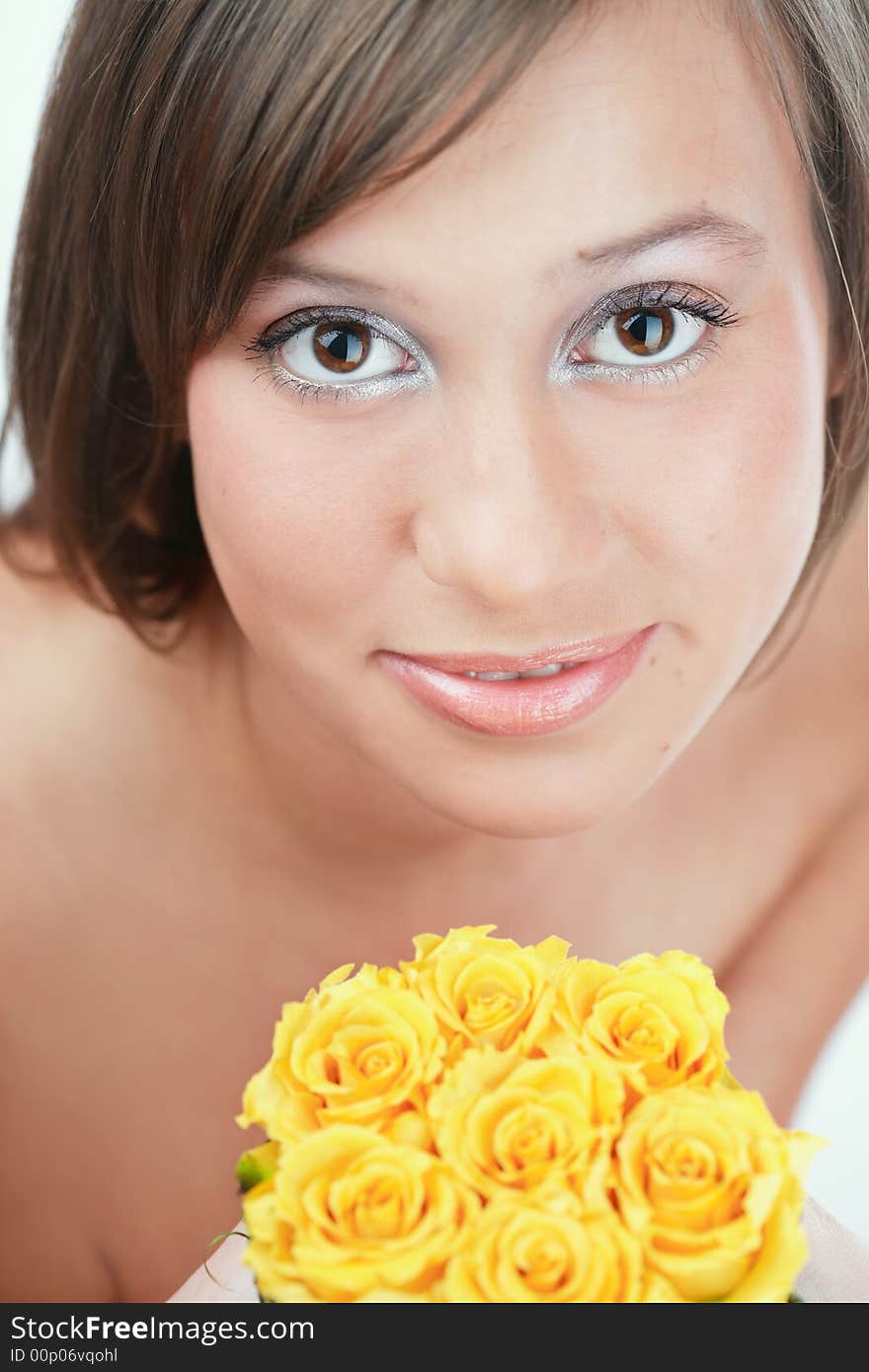 Portrait pf pretty brown-eyed girl holding yellow roses in hands. Portrait pf pretty brown-eyed girl holding yellow roses in hands