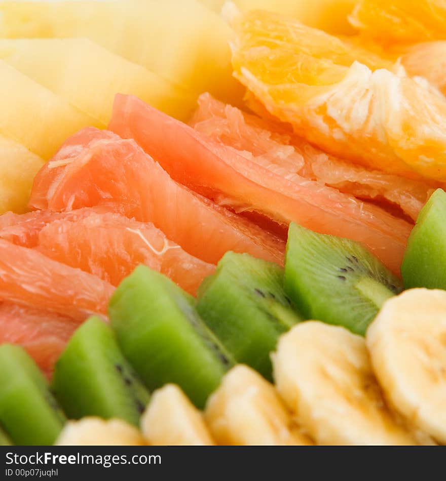 Fruit salad made of banana, kiwi, orange, grapefruit and pineapple isolated on white